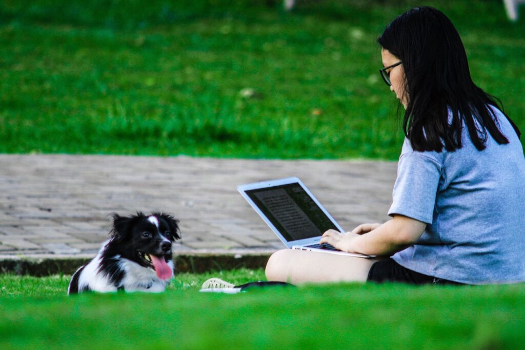 Girl studying in the park with her dog