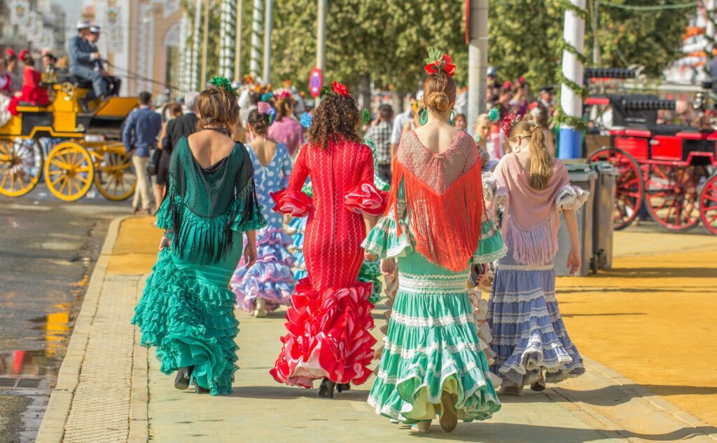 Four women in colourful dresses at a feria in Andalusia in Spain